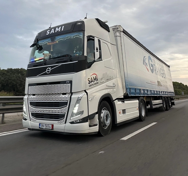 Camion Volvo modern si semiremorca cu prelata fotografiate in mers pe autostrada
