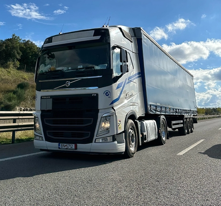 Ansamblu format din cap tractor Volvo si semiremorca cu prelata fotografiate pe autostrada
